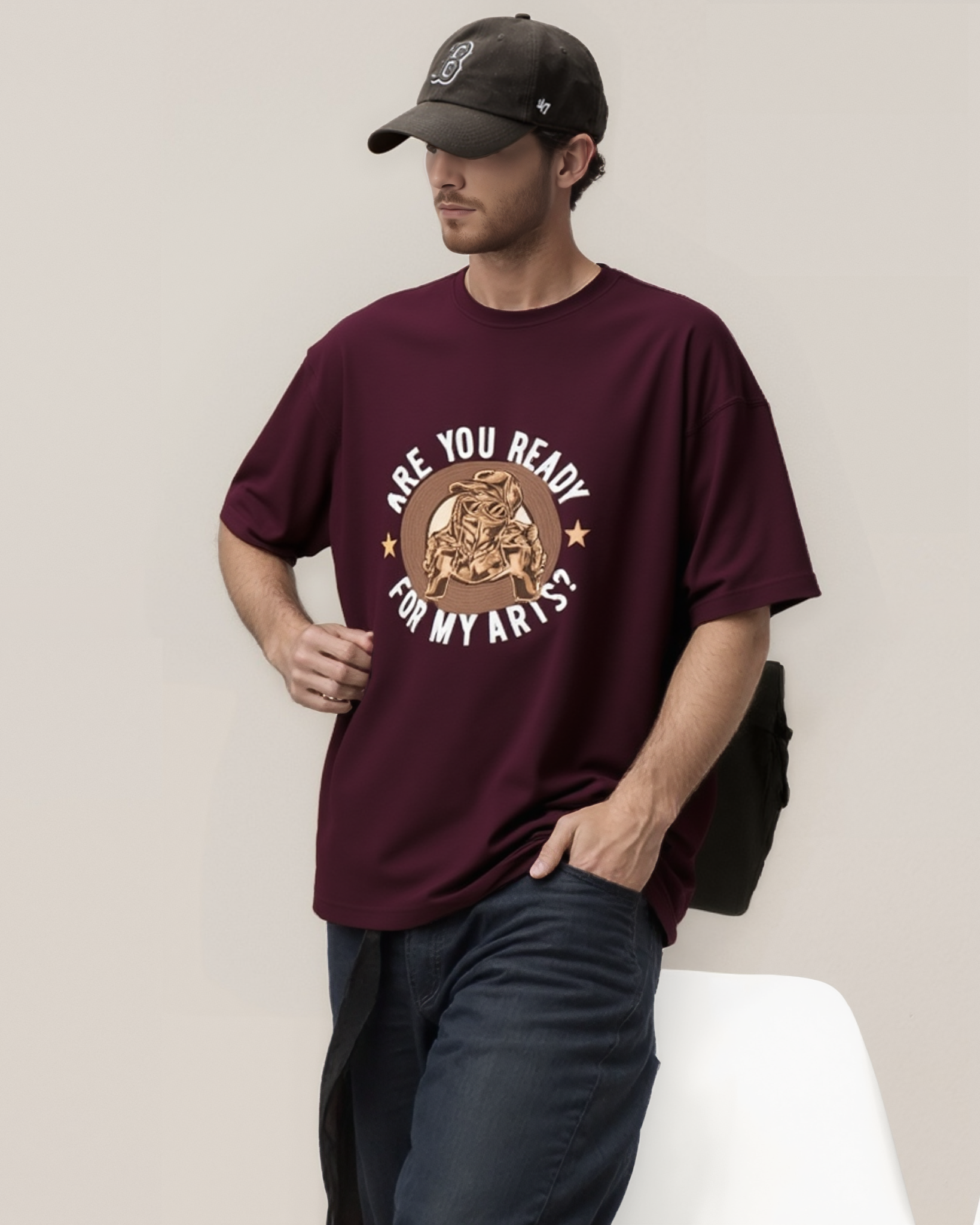 Man wearing a maroon t-shirt with graphic design and text, standing against a plain background