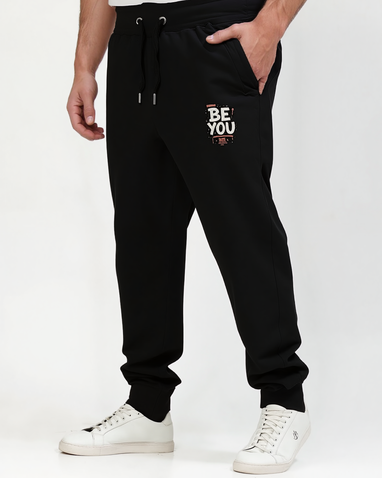 Black jogger pants with 'BE YOU' text on a white background