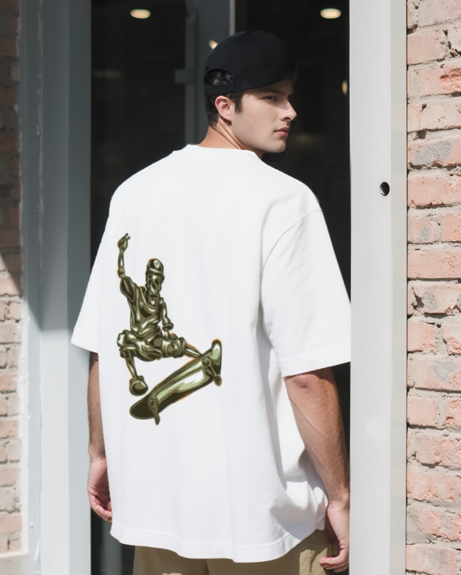 Person wearing a white t-shirt with a graphic design, beige shorts, and white sneakers, standing in front of a brick wall.